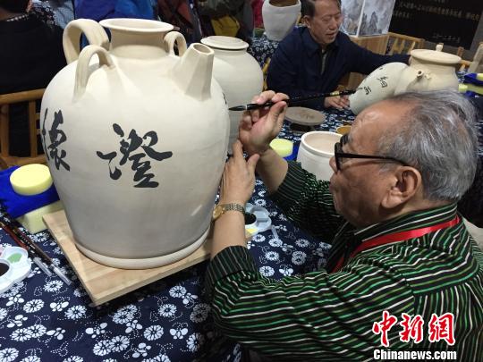 書(shū)法名家在陶瓷收藏壺上進(jìn)行創(chuàng)作!±羁〗堋z